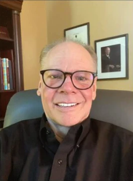 Headshot of Mike Peterson wearing glasses and a black shirt.